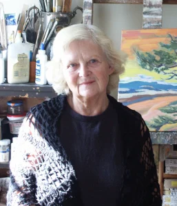 Portrait of Ludmila standing in front of one of her drawings.